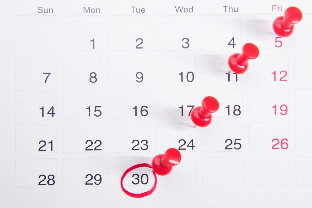 a calendar with red pins and a circle in the middle